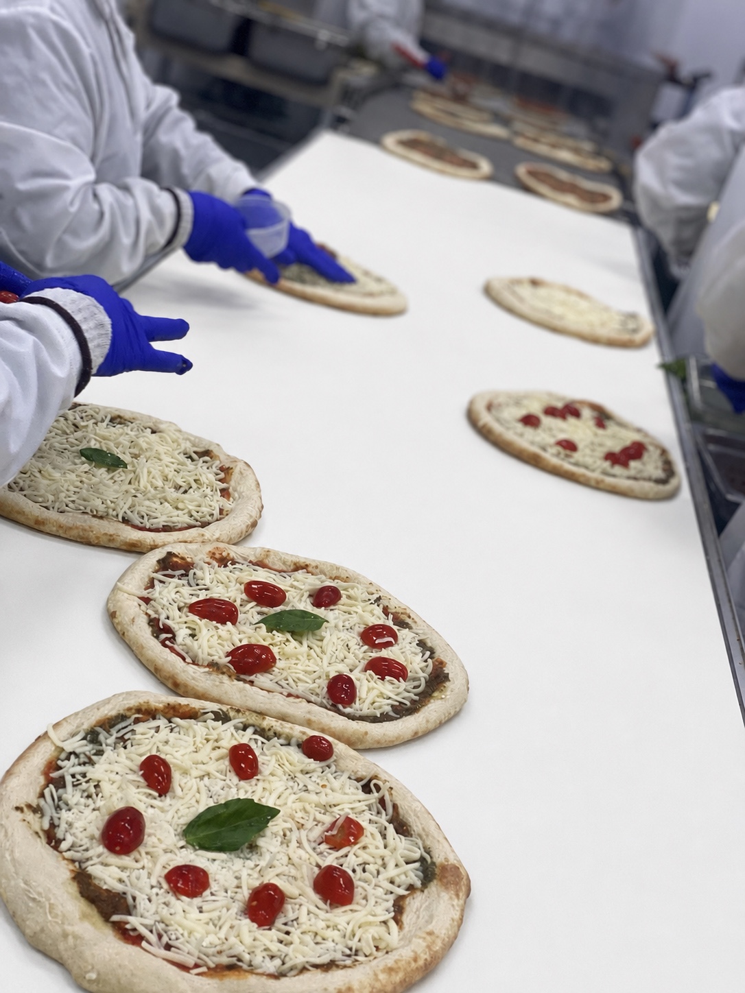 Pizzas artisanales sur la ligne de production